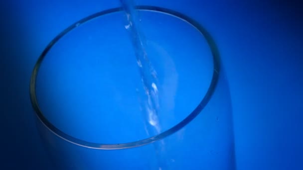 Bicchiere d'acqua su fondo blu — Video Stock