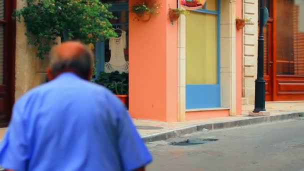 Un hombre caminando por la calle de un pequeño pueblo — Vídeos de Stock