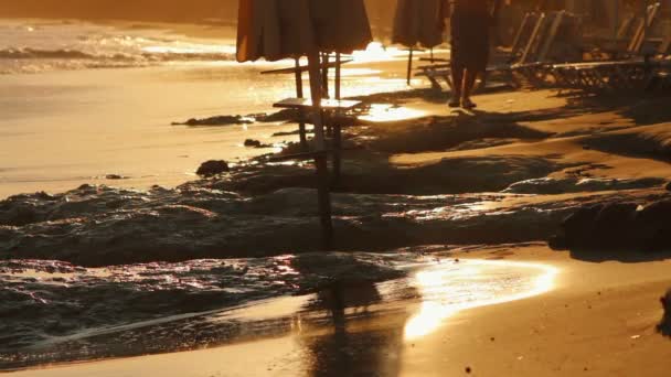 Hombre caminando por la playa al atardecer — Vídeos de Stock