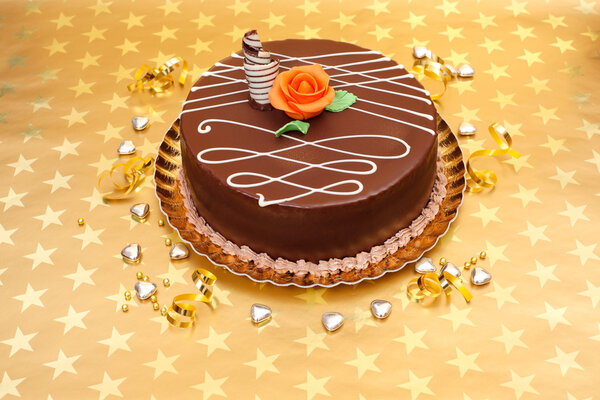 Chocolate cake on golden stars background