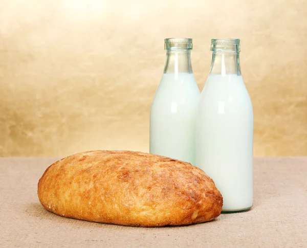 Whole bread and two milk bottles — Stock Photo, Image
