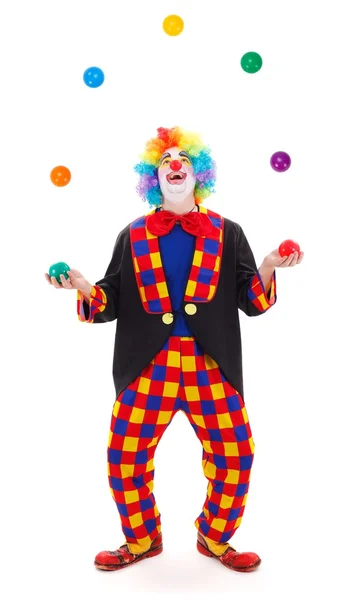 Жонглер-клоун бросает разноцветные мячи — стоковое фото