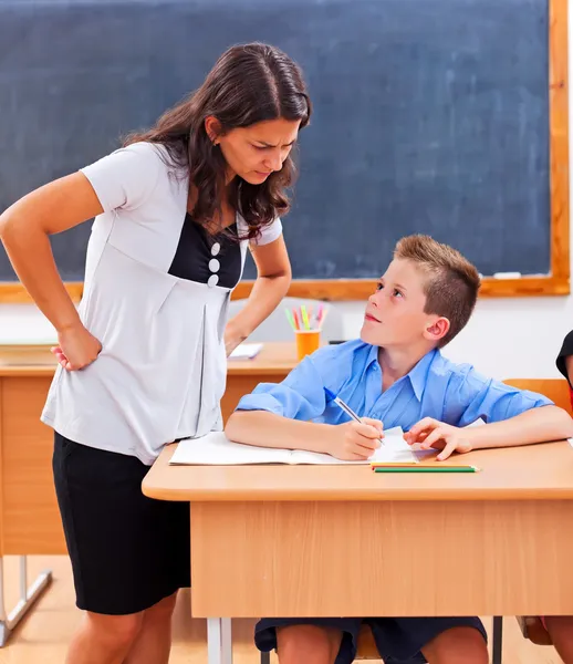 Leraar kijken naar leerling van huiswerk — Stockfoto