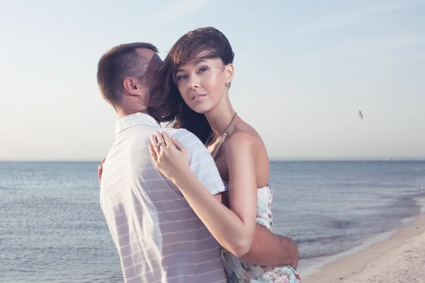 Retrato de casal bonito feliz desfrutando na praia no pôr do sol — Fotografia de Stock