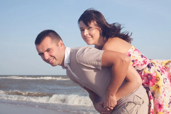 Portret van een man die een vriendin op zijn rug draagt — Stockfoto