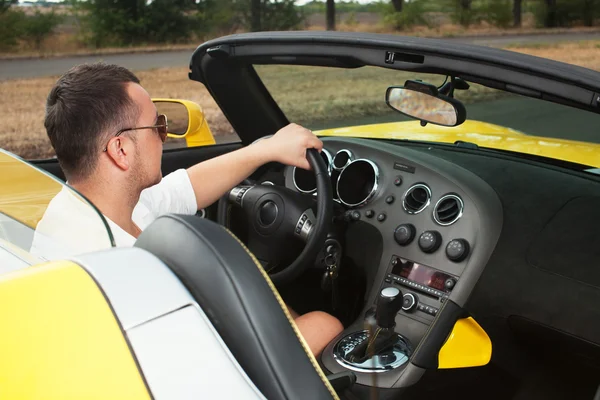 Un hombre elegante dirigiendo un taxi amarillo. interior del vehículo. vista superior — Foto de Stock