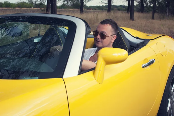 Trendy young man driving two seat cabrio car — Stock Photo, Image