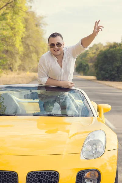 Lykkelig sjåfør av gul cabio. Seiersskilt – stockfoto