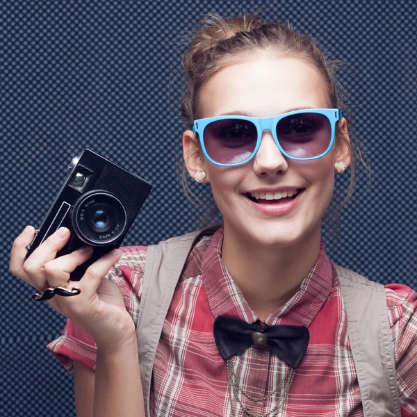 Portrait of beautiful hipster style young woman in white shirt and bow-tie. Old camera hanging by the neck — Stock Photo, Image