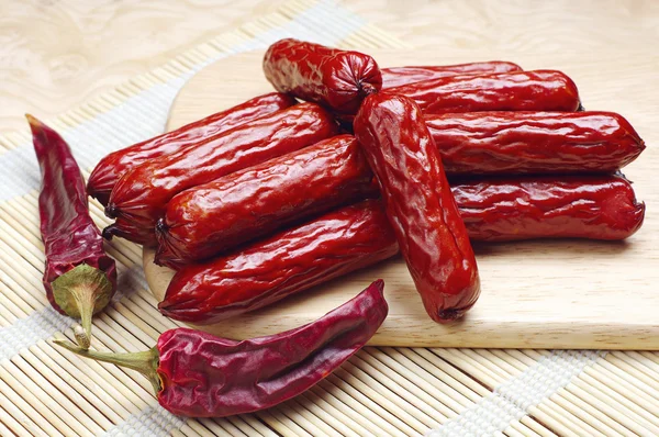 Smoked sausages and dry chili peppers — Stock Photo, Image