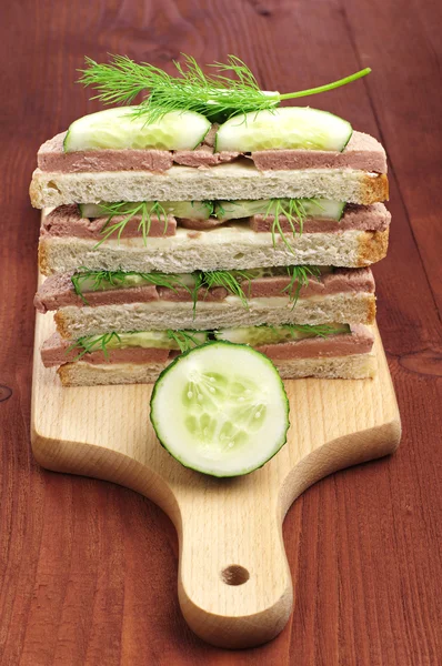 Sanduíches com salsicha de fígado e pepino na tábua de corte — Fotografia de Stock