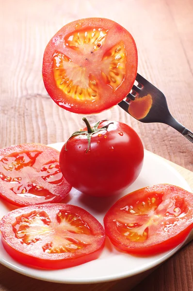 Tomatenscheiben auf einer Gabel und in einem Teller — Stockfoto