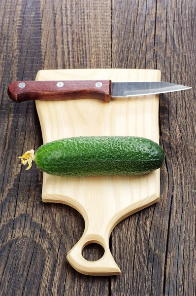 Een verse komkommer op snijplank — Stockfoto