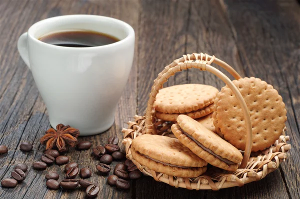 Ciasteczka w wiklinowym koszu i filiżankę kawy — Zdjęcie stockowe