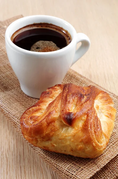 Cup of hot coffee and bun — Stock Photo, Image