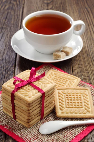 Cookies tied ribbon and cup of tea — Stock Photo, Image