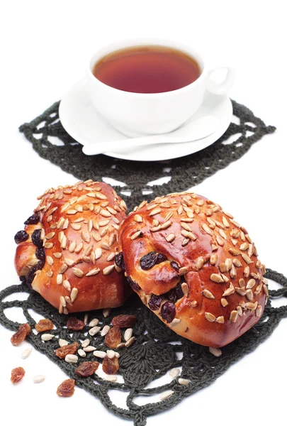 Twee broodjes met rozijnen en zonnebloempitten en kopje thee — Stockfoto