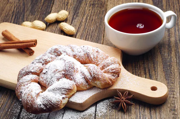 Braided bun and cup of tea closeup — Stock Photo, Image