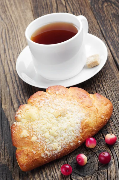 Zoet broodje met kopje thee — Stockfoto