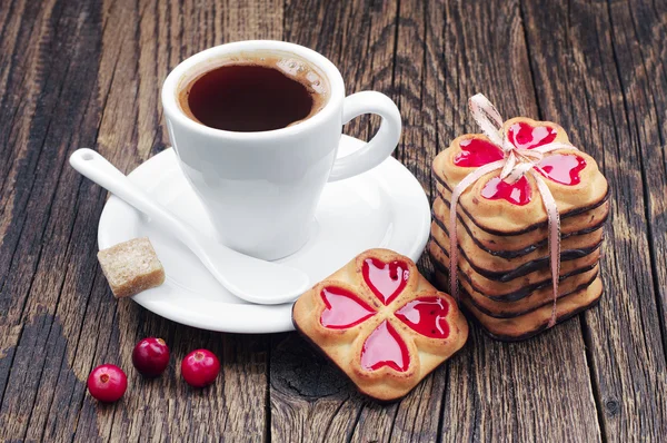 Beker van warme koffie en koekjes gebonden lint — Stockfoto