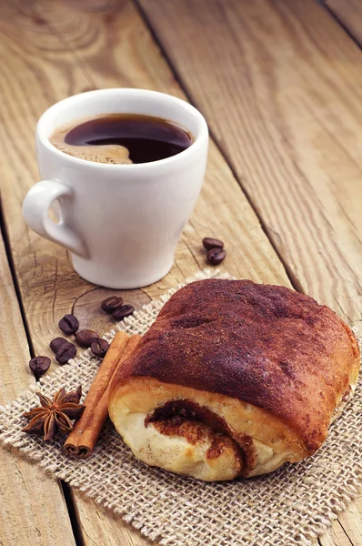 Delicious bun and cup of coffee — Stock Photo, Image