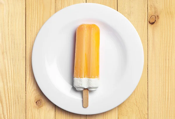 Апельсиновое мороженое растаяло в тарелке — стоковое фото