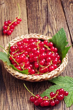 ahşap masa üstünde kırmızı kuş üzümü