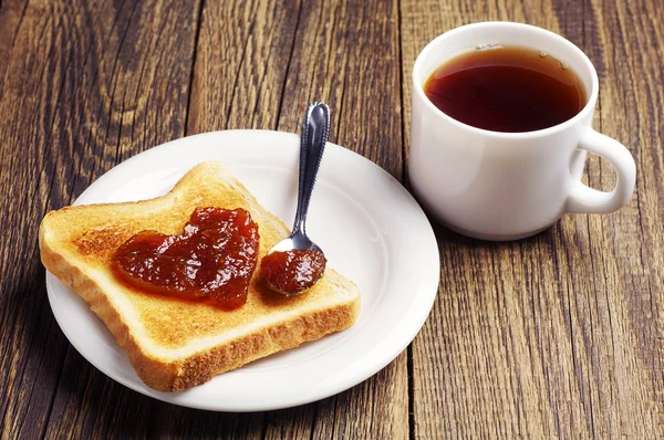 Thee en toast brood met jam in de vorm van harten — Stockfoto