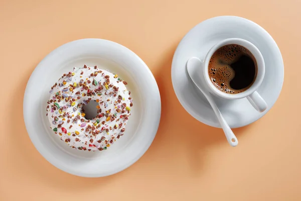 Чашка Кофе Сладкий Пончик Глазурью Бежевом Фоне Вид Сверху — стоковое фото