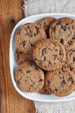 Tabakta çikolatalı kurabiyeler, ahşap masa, üst manzara.