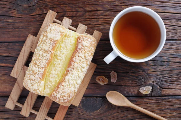 Kremalı Tatlı Çörek Ahşap Arka Planda Bir Fincan Çay — Stok fotoğraf