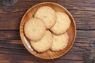 Lezzetli yulaf kurabiyeleri ahşap tabakta, eski masada, üst tarafta.