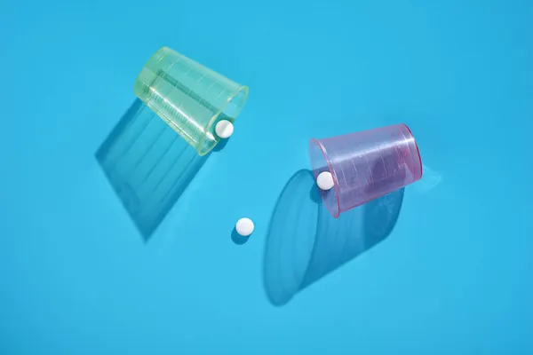 Medizinische Pillen Und Plastikbrillen Auf Blauem Hintergrund Draufsicht — Stockfoto