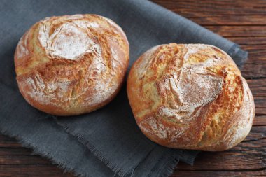 Küçük somun ekmeği ahşap masa üzerinde, yakın plan.