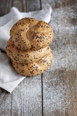 Kırsal ahşap masada keten tohumlu ekmek ruloları.