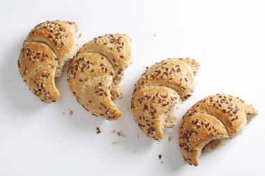 Beyaz arka planda keten tohumlu küçük ekmekler, üst görünüm