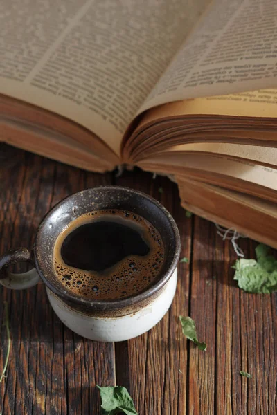 コーヒーのカップとテーブルの上の古い本 — ストック写真