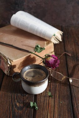 fincan kahve ve masanın üzerine eski kitap