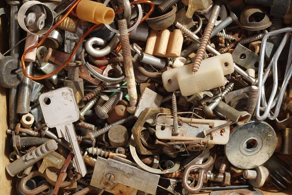 Eski, paslı vida yığını ve diğer metal parçalar bir kutuda, üst görünüm