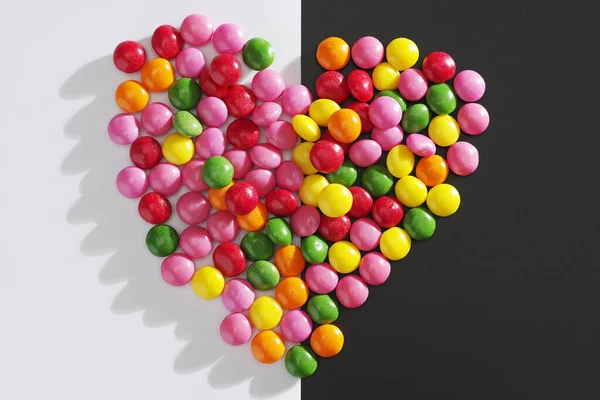 2トーンの背景にハートの形をしたカラフルな甘いキャンディー トップビュー — ストック写真