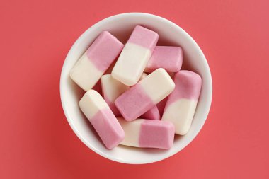 Arka planda pembe bir kasede meyveli şekerleme, üst manzara.