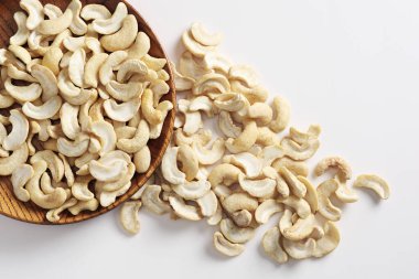 Ahşap tabakta kaju fıstığı veya Hint fındığı ve beyaz arka planda, üst manzara 