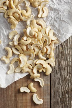 Ahşap arka planda buruşmuş kağıt üzerinde kaju ya da Hindistan cevizi. 