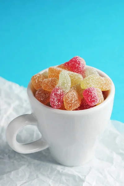 Xícara Goma Colorida Geléia Verme Doces Papel Amassado Fundo Azul — Fotografia de Stock