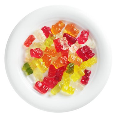 Beyaz arka planda izole edilmiş bir tabakta çok renkli çiğneme şekeri ayıları.