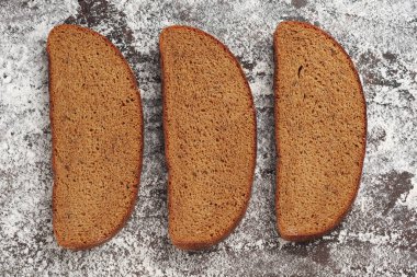 Arkaplanda un olan çavdar ekmeği dilimleri.