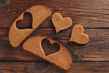 Ahşap zemin üzerinde kalp şeklinde çavdar ekmeği dilimleri.