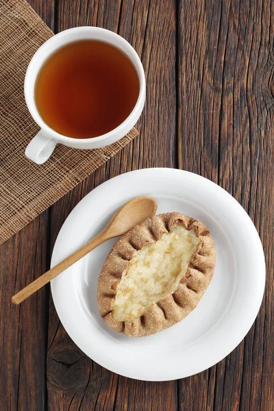 ライスプディングと木の背景にお茶のカップとパン トップビュー — ストック写真