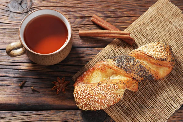 木の背景に種のあるおいしいパンと熱いお茶のカップ トップビュー — ストック写真