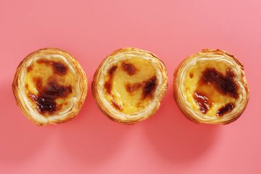 Pembe arka planda geleneksel Portekiz yumurtalı tart tatlısı.